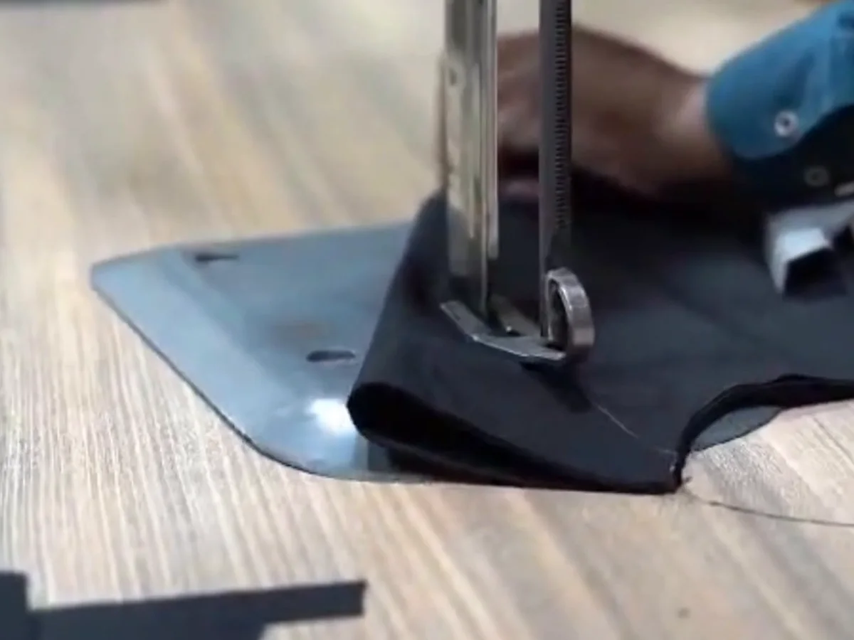 Straight-knife cutter going through a lay of fabric on the cutting table