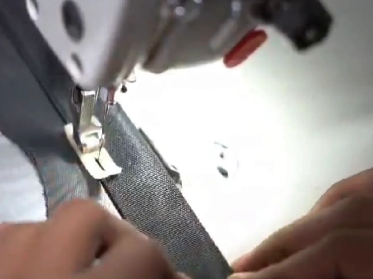 Machinist guiding a seam under the needle on the stitching floor